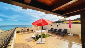 um pátio com uma mesa e um guarda-chuva vermelho em Tropical penthouse em Rincón de la Victoria