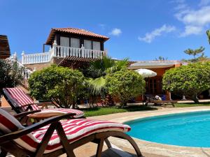 um par de cadeiras sentadas ao lado de uma piscina em Luxury Villa Los Gigantes em Puerto de Santiago