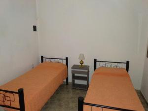 Habitación con 2 camas y mesa con lámpara. en Casa en Santa Rosa de Calamuchita en Santa Rosa de Calamuchita