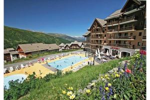 a resort with a swimming pool and some buildings at Appartement aux pieds des pistes in Valmeinier