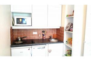 a small kitchen with a sink and a microwave at Appartement aux pieds des pistes in Valmeinier