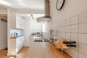 Two Bed Apartment Bowness-On-Windermere 2022Refurb في باونيس أون وينديرمير: مطبخ بجدران بيضاء وساعة على الحائط