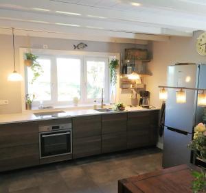 a kitchen with a sink and a refrigerator at Vinkelaar 11 in Terschuur +28 photos