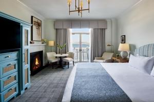 Habitación de hotel con cama y chimenea en Harbourview Inn en Charleston