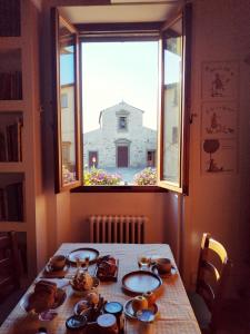 une table dans une chambre avec une fenêtre donnant sur un bâtiment dans l'établissement B&B "La Pieve" - Locanda per Viandanti, à San Piero a Sieve