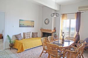 een woonkamer met een bank en een tafel bij Nami Sea View Near Airport Apartment in Artemida