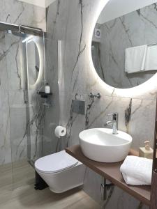 a bathroom with a sink and a toilet and a mirror at Gennadi Beach Apartments in Gennadi