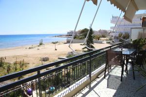 een balkon met uitzicht op het strand bij Nami Sea View Near Airport Apartment in Artemida