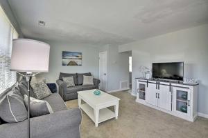 sala de estar con sofá y TV en Sunny Norfolk Duplex - Walk to Lake and Beach!, en North Camellia Acres
