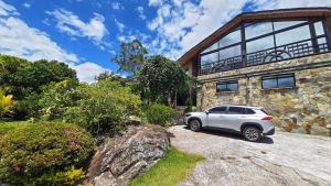 een witte auto geparkeerd voor een stenen huis bij The Residence by Villa Alejandro in Boquete