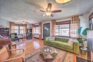 a living room with a green couch and a ceiling fan at Amazing Musical Abode in Expo Square Neighborhood! in Tulsa