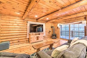 a living room with a couch and a table and a tv at Spacious Cabin with Decks Near Saratoga Springs in Middle Grove
