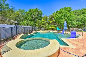 una piscina en un patio trasero con sillas azules en Sun-Soaked Sarasota Oasis with Pool and Hot Tub!, en Sarasota