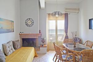 een woonkamer met een tafel en een open haard bij Nami Sea View Near Airport Apartment in Artemida