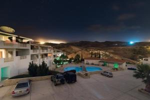 uitzicht op een parkeerplaats met zwembad in de nacht bij Peyia Resort Apartment in Peyia