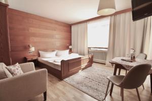 una camera d'albergo con letto, tavolo e sedie di Alpenhaus Monte a Neustift im Stubaital
