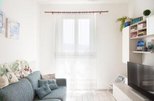 uma sala de estar com um sofá azul e uma janela em Carola's Home - Goelba em Portoferraio