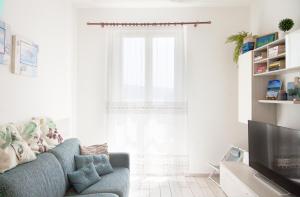 a living room with a blue couch and a window at Carola's Home - Goelba in Portoferraio