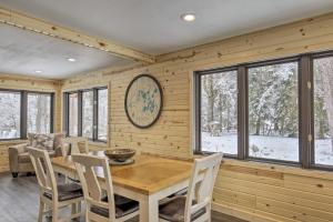 a dining room with a table and chairs and windows at Deerskin Lodge with Boat Dock and Fire Pit! in Eagle River