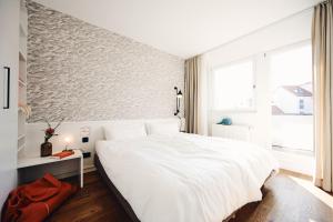 Un dormitorio blanco con una cama grande y una ventana en Haus am Meer-Ferienwohnungen, en Norderney