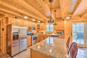 a kitchen with wooden cabinets and a stainless steel refrigerator at Charming Cabin with Deck, 10 Min to Bretton Woods! in Carroll