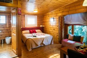a bedroom with a bed in a wooden cabin at Hotel Somlom - ECO Friendly Montseny in Sant Esteve de Palautordera
