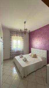 sypialnia z dużym łóżkiem i różową ścianą w obiekcie Appartamento Canalotto 65 2 piano w mieście Realmonte