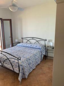 een slaapkamer met een bed met een blauw dekbed bij Villino Caddu in San Teodoro