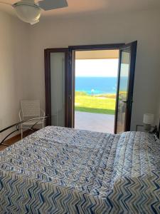een slaapkamer met een bed met uitzicht op de oceaan bij Villino Caddu in San Teodoro