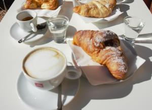 - une table blanche avec un plateau de pâtisseries et une tasse de café dans l'établissement Palazzo Liberty BnB, à Bologne 49 autres photos