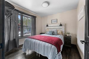 a bedroom with a bed with a red blanket and a window at Whiskey Hills At Terry Peak in Lead