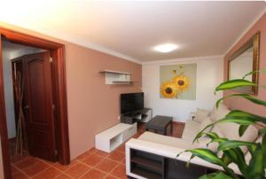 salon z białą kanapą i telewizorem w obiekcie Villa con piscina, vistas, dunas, mar, 6 personas w Corralejo