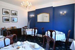 a dining room with two tables and a mirror at Avoncot Guest House in Stratford-upon-Avon