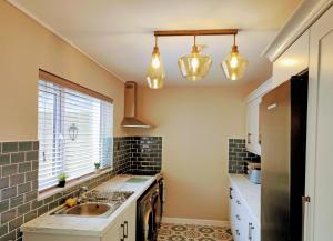 a kitchen with a sink and a stove at Tralee Townhouse Holiday Home in Tralee