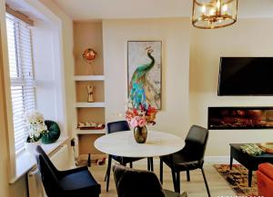 a living room with a table and a peacock painting at Tralee Townhouse Holiday Home by Trident Holiday Homes in Tralee