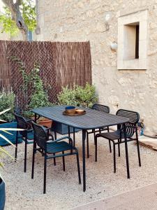 a black picnic table and chairs in a yard at La Blanchisserie in Maussane-les-Alpilles