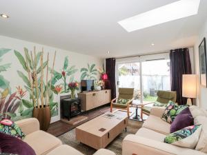 a living room with two couches and a tv at Tile Cottage in Lymington