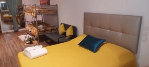 a bedroom with a large yellow bed and a couch at AL "Hospedaria Por do sol" Sunset Olhao in Olhão