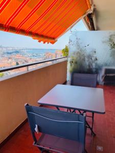 a table and chairs on a balcony with a view at Le Suquetan in Cannes