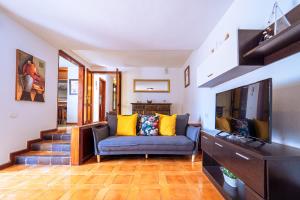 uma sala de estar com um sofá e uma televisão de ecrã plano em Beatifull Villa El Duque & Private Pool em Poris de Abona