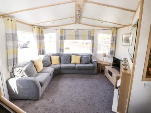 a living room with a couch and a tv at The Maples in Millom