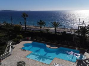 a swimming pool with the ocean in the background at Appartement en bord de mer in Cannes