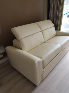 a white leather couch in a room with a window at Appartement en bord de mer in Cannes