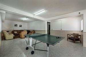 a ping pong table in a room with a living room at Villa Cadre in Armação de Pêra