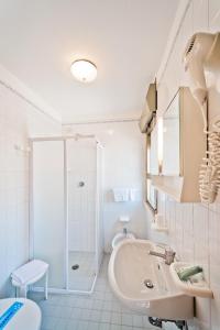 baño blanco con ducha y lavamanos en Hotel Bianchi, en Bibione