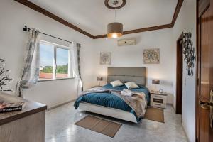 - une chambre avec un lit et une grande fenêtre dans l'établissement Villa Cadre, à Armação de Pêra