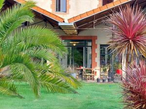 a house with palm trees in front of a yard at Laiterie de Tocqueville in Tocqueville