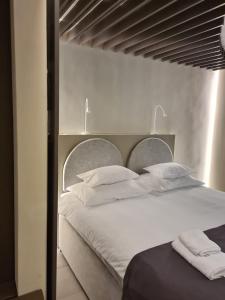 ein Schlafzimmer mit einem großen Bett mit weißer Bettwäsche und Kissen in der Unterkunft Hotel Emaus in Novigrad Istria