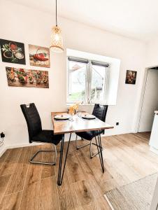 a dining room with a wooden table and black chairs at Holiday Home Amélie in Bollendorf