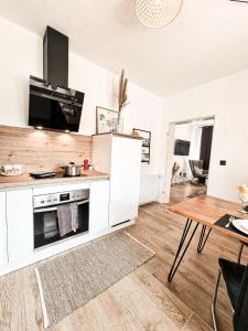 a kitchen with white appliances and a wooden table at Holiday Home Amélie in Bollendorf